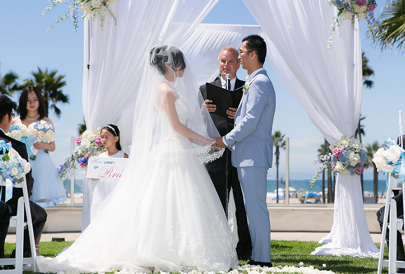 Couple saying I DO at their wedding ceremony filled with beautiful wedding decorations in Orange County http://RoyceWeddings.com Call: 626-560-2537